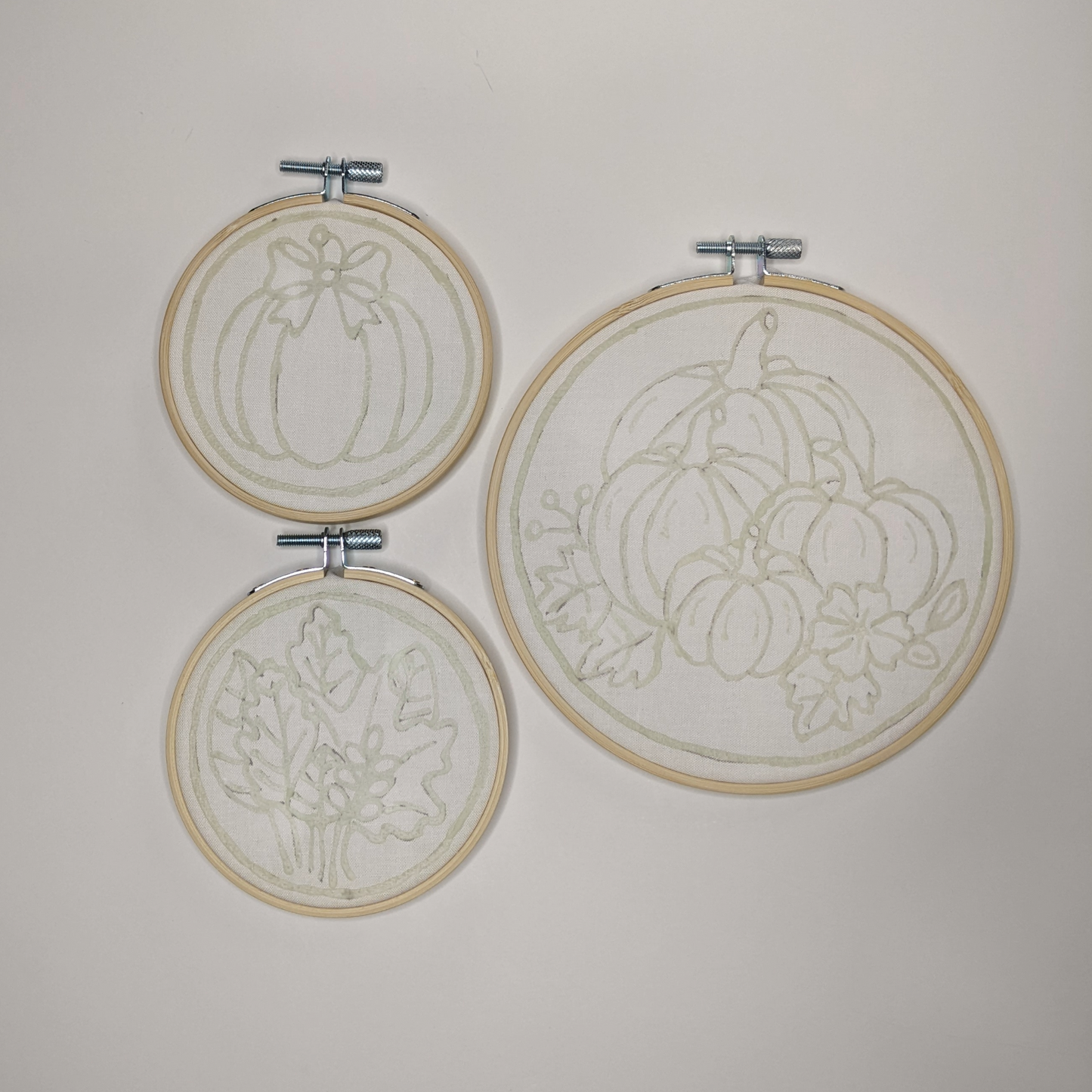 Three hoops with pre-waxed designs of pumpkins and fall leaves.